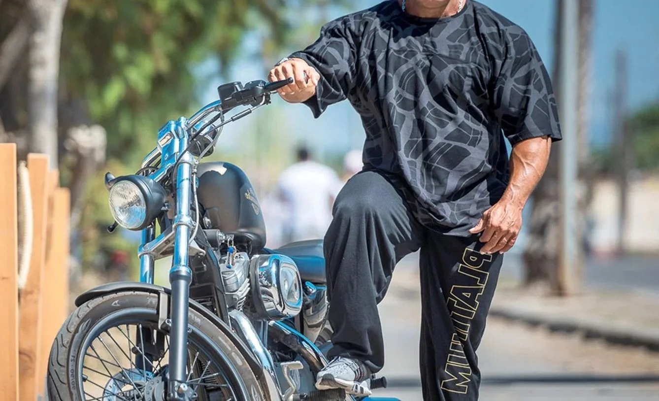 Oversized camo rag top και μαύρη φόρμα Platinum δίπλα σε μοτοσυκλέτα